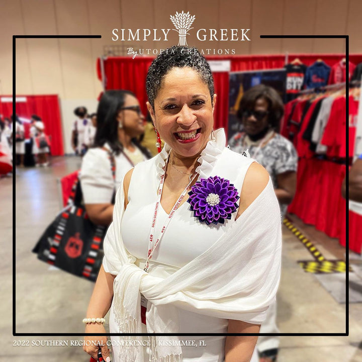 Smiling woman wearing an African Violet Flower Corsage Pin by Utopia Creations.  